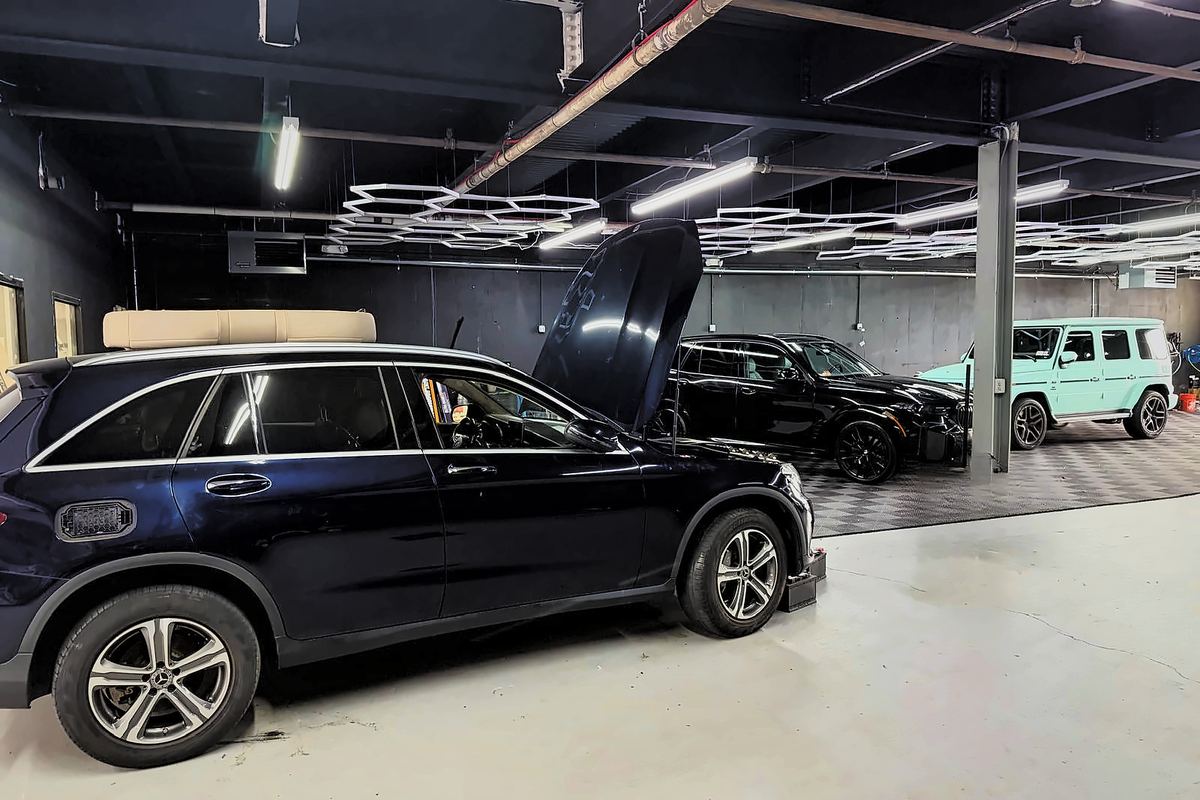 Mercedes GLC with hood open beside a black SUV