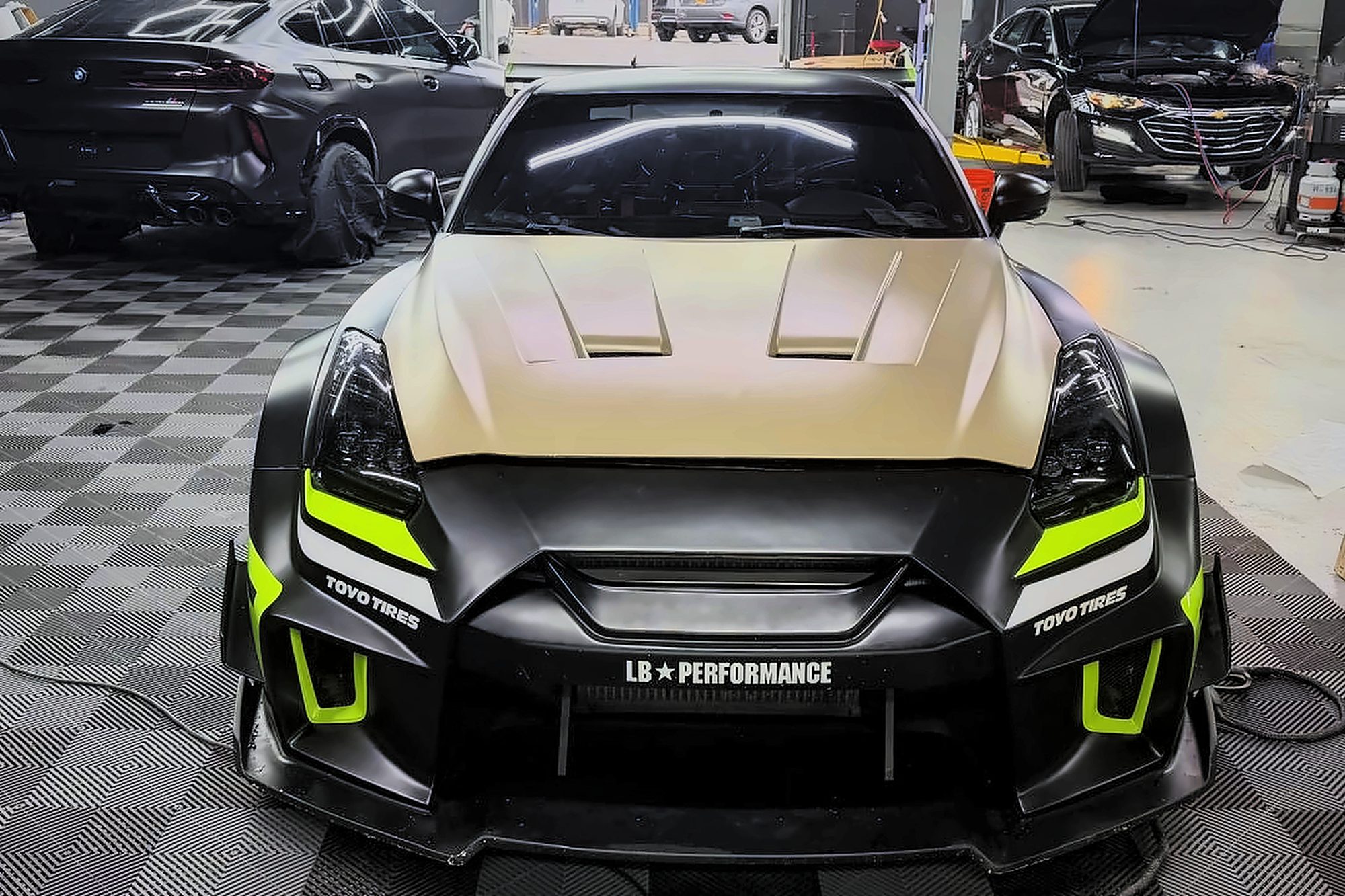 Widebody Nissan GT-R with matte gold hood, finished at Triforce Auto Repair