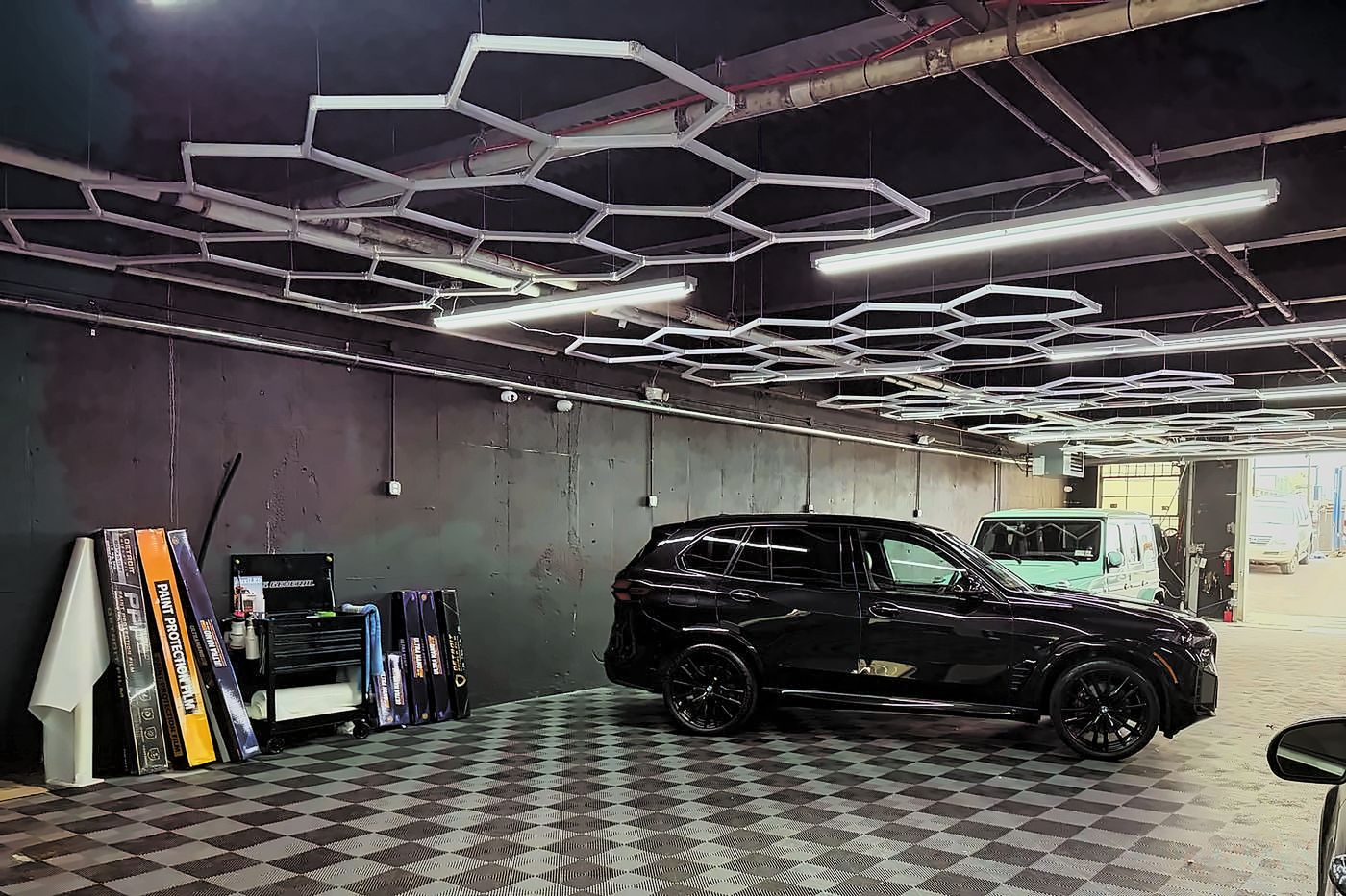 Rolls of paint protection film and tint stock on the detail side of the shop